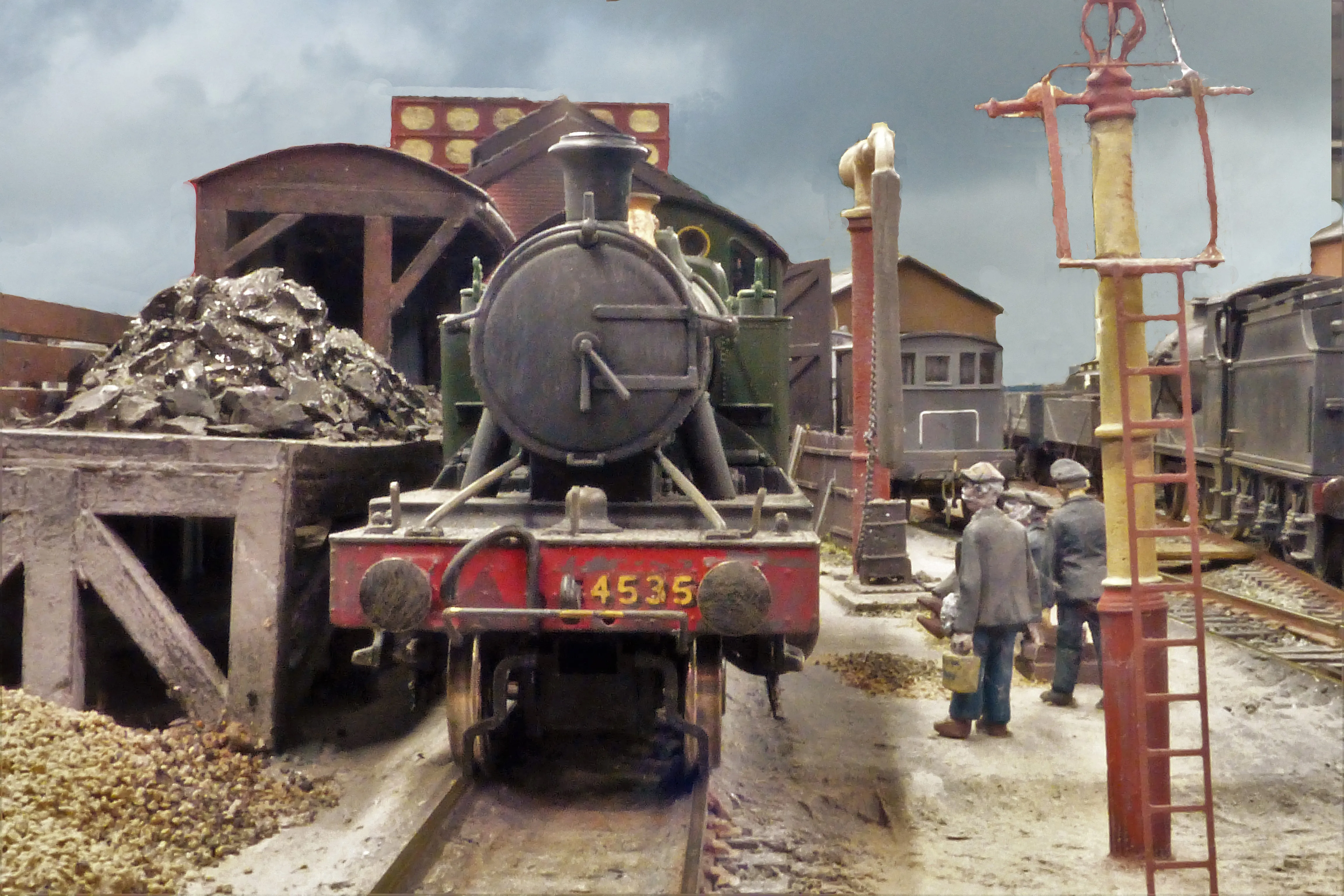 The front of a steam train as it refills with coal at the yard